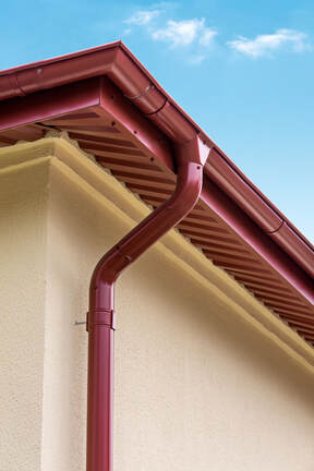 Dark red gutter with downspout.  Pretty house
