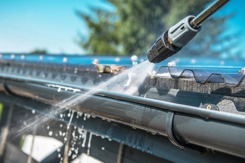 Hosing out rain gutters with a pressure nozzle